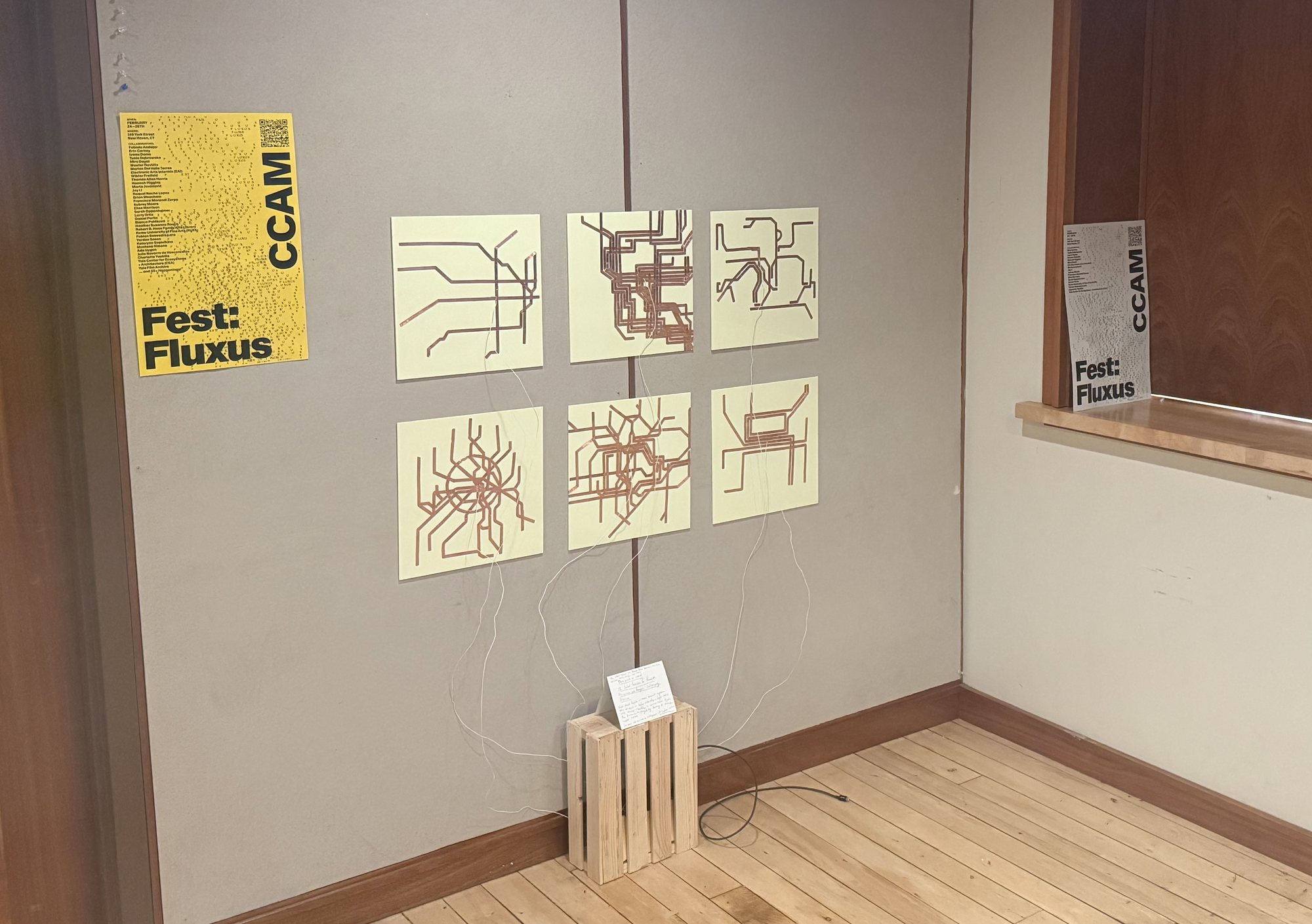 Wide view of the corner with the maps, the poster and a crate on the wooden floor.